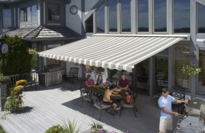 Family enjoying a barbeque in the shade of a house awning
