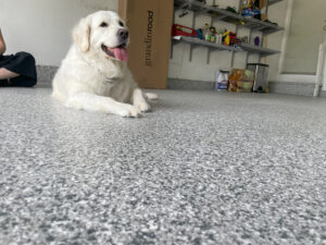 Dog laying on a polyurea garage floor coating installation by Trim-A-Seal Home Improvements in Crown Point, IN